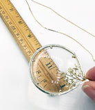 Elegant Magnifying Glass Rose Pendant on Gold Tone Metal Necklace